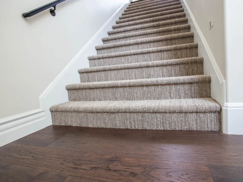 Light beige carpeted stairway dark vinyl floor | Nielson Fine Floors | Lincoln, CA