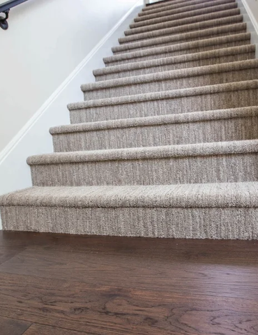 Light beige carpeted stairway dark vinyl floor | Nielson Fine Floors | Lincoln, CA
